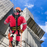 Man working at height in a suspension safety harness